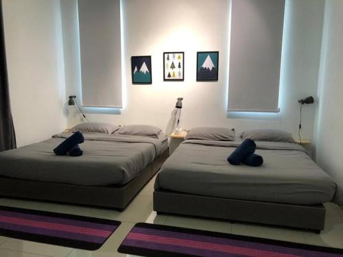 two beds sitting in a room with two windows at Desaru Fun House For Family-Kids-AirCastle-BBQ-KTV in Bandar Penawar