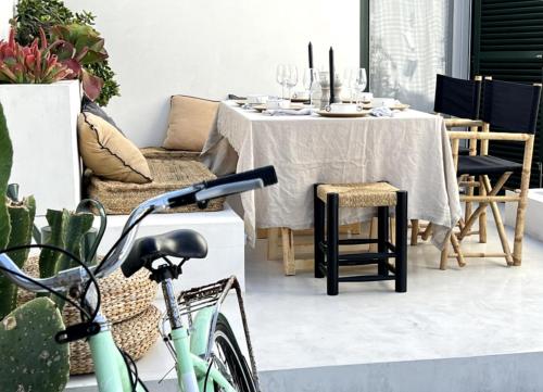 una bicicletta parcheggiata di fronte a un tavolo da pranzo di Can Taronger Menorca a Cala'n Forcat