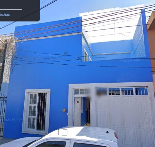a blue house with a white van parked in front of it at Casa Camacho in Oaxaca City