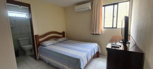 1 dormitorio con cama, escritorio y lavamanos en Residencial Mar de Gênova - Bessa, en João Pessoa