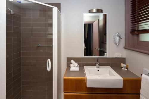 a bathroom with a sink and a shower at Central Hotel Hobart in Hobart