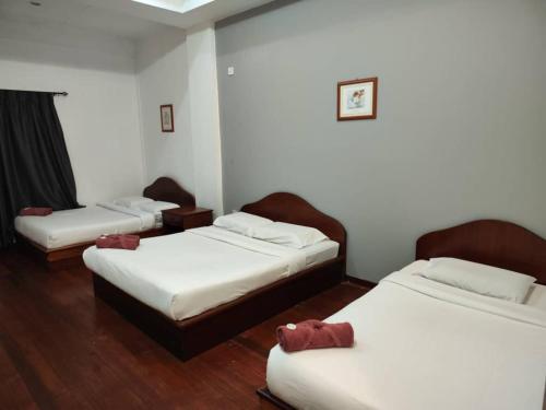 three beds in a room with wooden floors at Fairy Garden Resort Kundasang in Kundasang