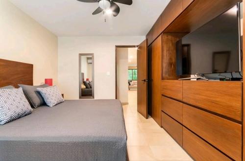 um quarto com uma cama e uma televisão de ecrã plano em Departamento Céntrico y Moderno en Cancún. em Cancún