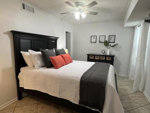1 dormitorio con 1 cama y ventilador de techo en Condo on the Beach- walk to restaurants, shops and activities. en Gulf Shores