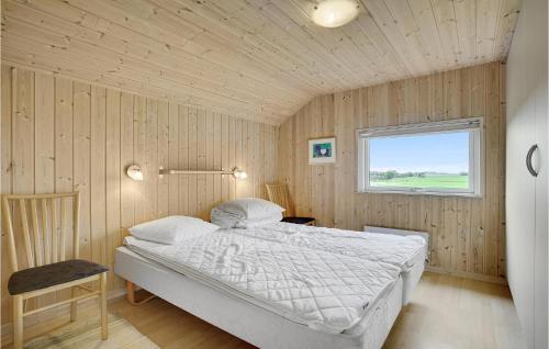 1 dormitorio con 1 cama en una pared de madera en Awesome Home In Stege With Sauna en Stege