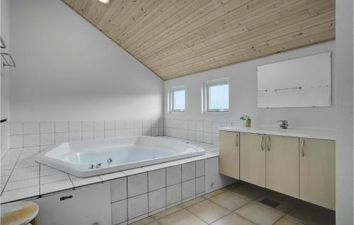 Baño blanco con bañera y lavamanos en Awesome Home In Stege With Sauna en Stege
