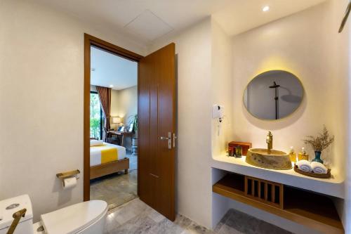 a bathroom with a sink and a toilet and a mirror at Nam An Mama Villa Hoi An in Hoi An