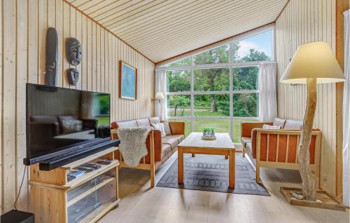 a living room with a large tv and a couch at Four-Bedroom Holiday Home In Stege in Stege