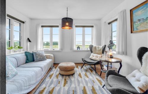 a living room with a couch and chairs and windows at Herligheden in Aabenraa