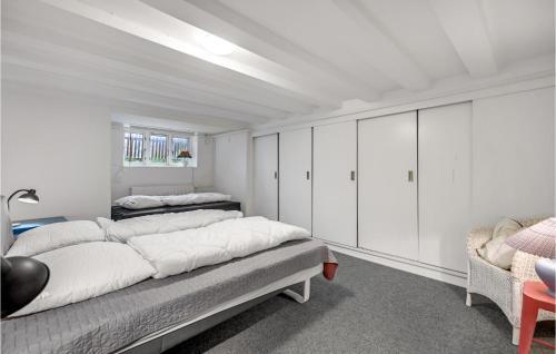 um quarto branco com 2 camas e uma cadeira em Beautiful Apartment In Aarhus C With Wifi em Aarhus