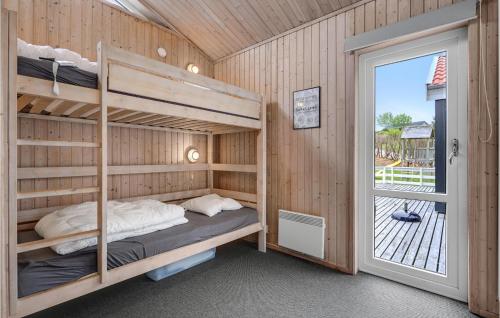 エーベルトフトにあるAmazing Home In Ebeltoft With 3 Bedrooms, Sauna And Indoor Swimming Poolのベッドルーム1室(二段ベッド付)、バルコニーへのドアが備わります。