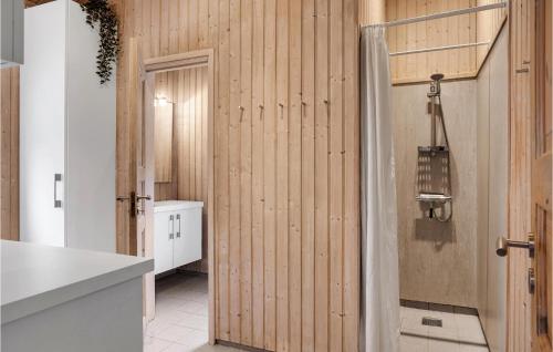 エーベルトフトにあるAmazing Home In Ebeltoft With 3 Bedrooms, Sauna And Indoor Swimming Poolの木製の壁とドアが備わるキッチン