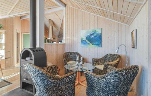 TjørneholmにあるCozy Home In Nykbing Sj With Saunaのテーブル、椅子、コンロが備わる客室です。