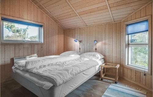 TjørneholmにあるCozy Home In Nykbing Sj With Saunaの木製の壁のベッドルーム1室(ベッド1台付)