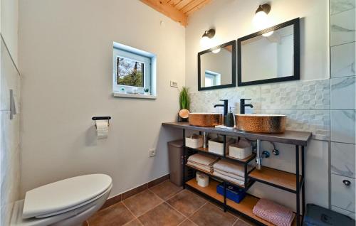 a bathroom with a toilet and two sinks at Gorgeous Home In Varazdinske Toplice With Kitchenette in Varaždinske Toplice