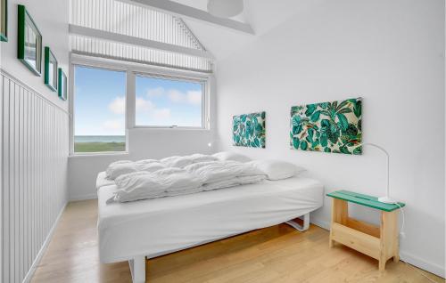 a white bedroom with a bed and a window at Awesome Home In Assens With House Sea View in Assens