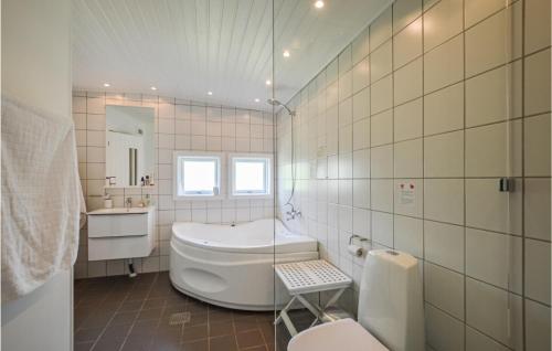 uma casa de banho com uma banheira, um WC e um lavatório. em Coras Hytter em Fårevejle