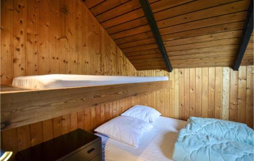 エーベルトフトにあるBeautiful Home In Ebeltoft With 3 Bedroomsの木造キャビン内のベッド1台