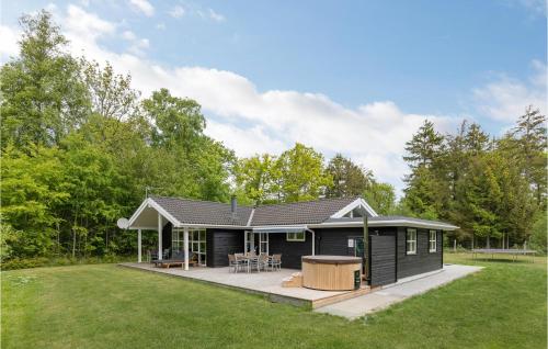 a black modular house with a deck in a yard at Holiday Home Toftegårdsvej Hasle X in Tofte