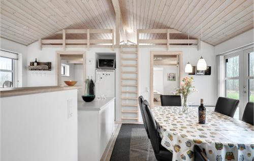 a kitchen and dining room with a table and chairs at Holiday Home Toftegårdsvej Hasle X in Tofte