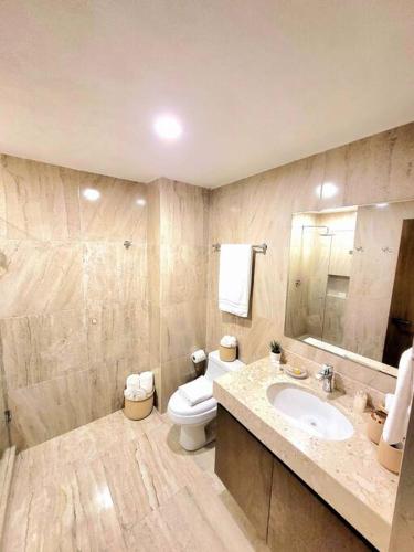 a bathroom with a white toilet and a sink at Departamento Céntrico y Moderno en Cancún. in Cancún
