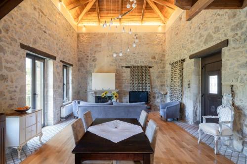 sala de estar con mesa y pared de piedra en Villa Lambraki en Síva