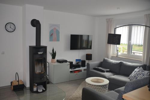 uma sala de estar com um sofá e um fogão a lenha em Haus Hummel em Lieske
