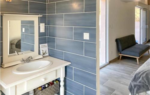 ein Badezimmer mit einem Waschbecken, einem Spiegel und einem Stuhl in der Unterkunft Gorgeous Home In Mercuer With Outdoor Swimming Pool in Mercuer