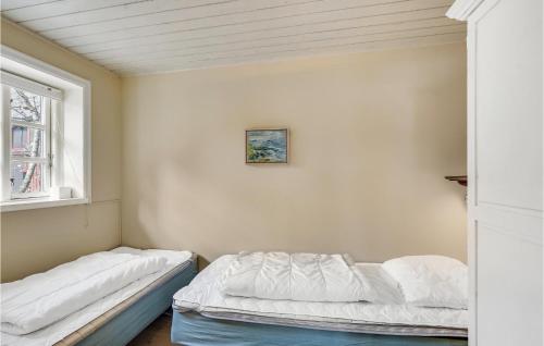 two beds in a room with a window at Amazing Home In Skrup Fyn With 1 Bedrooms And Wifi in Skårupøre