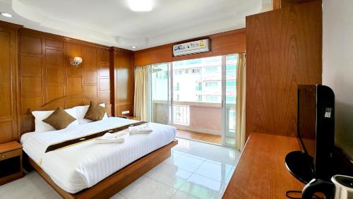 a bedroom with a large bed and a television at Chalita House in Patong Beach