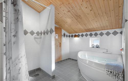 BjerregårdにあるLovely Home In Hvide Sande With Saunaの木製の天井のバスルーム(白いバスタブ付)