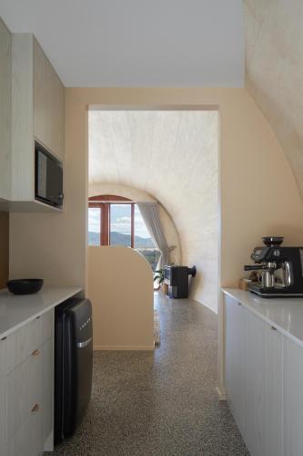 a kitchen with an archway in the middle of a room at Barrel View Luxury Cabins in Ballandean
