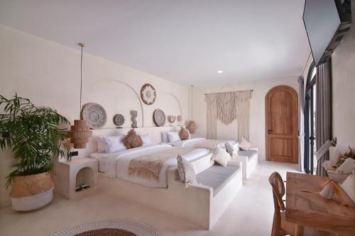 a white bedroom with a large bed and a couch at Bohemian Jogja Villas with Private Pool in Kejayan
