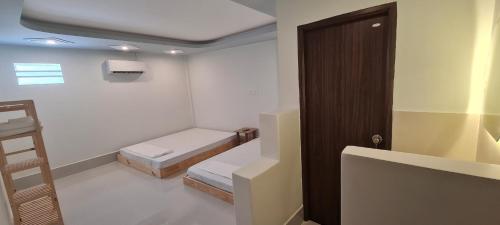 a small room with two beds and a ladder at Grandma House in Can Tho