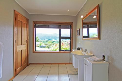 a bathroom with a sink and a mirror and a window at Riverview Lodge in Hanmer Springs