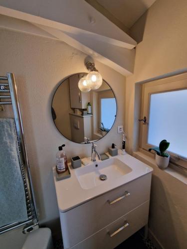 une salle de bain avec un lavabo et un miroir dans l'établissement MAISON BELLEVUE DE SAGRIES, à Sagriès