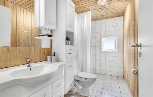 Baño blanco con lavabo y aseo en Nice Home In Vejers Strand With Kitchen, en Vejers Strand