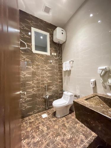 a bathroom with a toilet and a sink at شاليهات وفلل ريلاكس بلاس in Sirr Āl Ghalīz̧