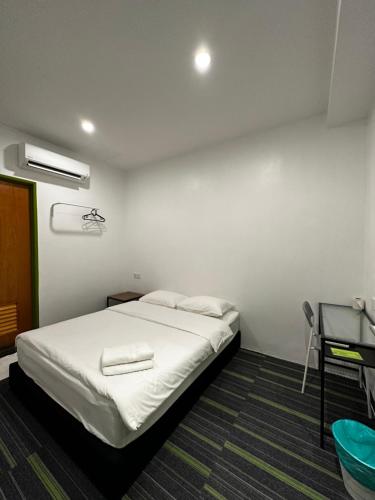 a bedroom with a white bed and a desk at Olive Bedz Hotel in Tambun