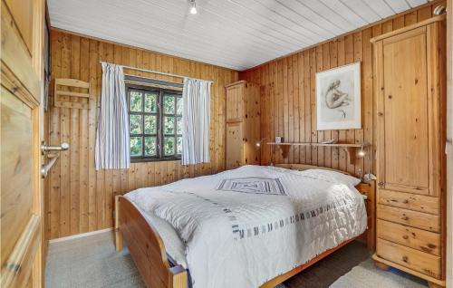 a bedroom with wooden walls and a bed in it at Stunning Home In Fan With Wifi in Fanø