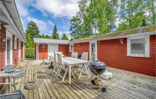 une terrasse avec un grill, une table et des chaises dans l'établissement 5 Bedroom Amazing Home In Rrvig, à Rørvig