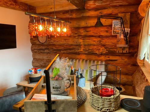 a room with a wooden wall with a chandelier at Blockhaus PanHütte in Braunlage
