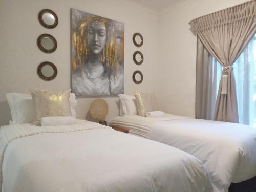 內爾斯普雷特的住宿－Endonini House，一间带两张床的卧室和一张女人的肖像