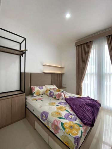 a bedroom with a large bed with a tv at Villa Permata Panderman 20 in Batu