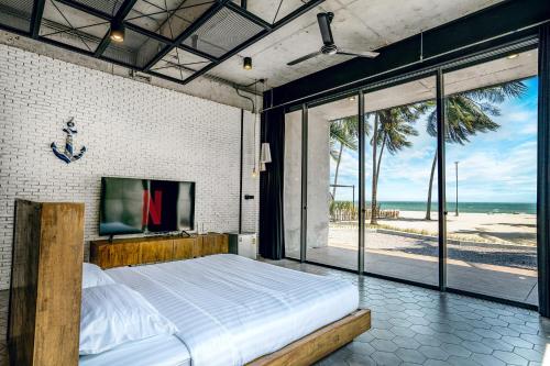 1 dormitorio con 1 cama grande y vistas a la playa en The Bloc @ Sea, en Thap Sakae