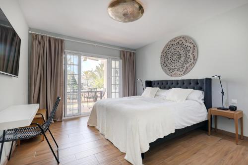 a bedroom with a large bed and a balcony at Luxurious apartment in Puente Romano, Marbella (Golden Mile) in Marbella