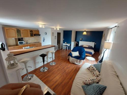 uma sala de estar com um sofá e uma cozinha em Gîte le Chausey Mont Saint Michel em Pontorson