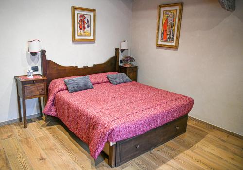 1 dormitorio con 1 cama con colcha rosa en Povillus - Dimora Medievale, en Quart