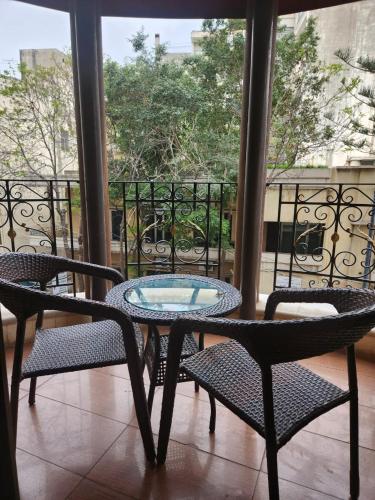 a patio with two chairs and a table and a window at Q Hotel in Beirut