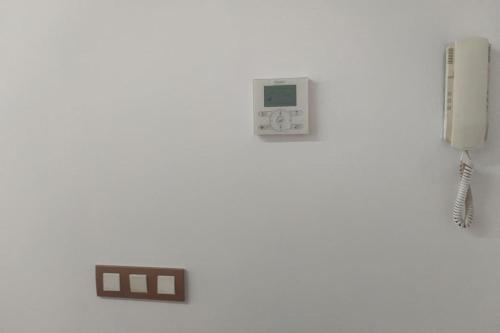 a phone and an electronic device on a white wall at Playa Puebla de Farnals Valencia in Masalfasar